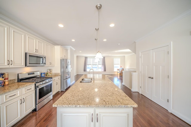 kitchen featuring stainless steel appliances, sink, pendant lighting, and a kitchen island with sink