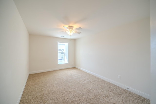 unfurnished room with light colored carpet and ceiling fan