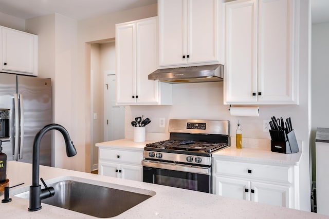 kitchen featuring light stone counters, stainless steel appliances, sink, and white cabinets