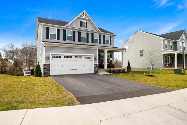 view of front of property featuring a garage, a porch, and a front yard