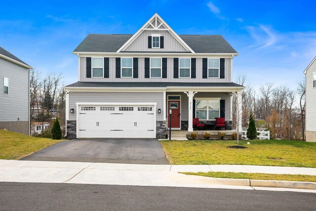 craftsman-style house featuring a garage, a porch, and a front yard