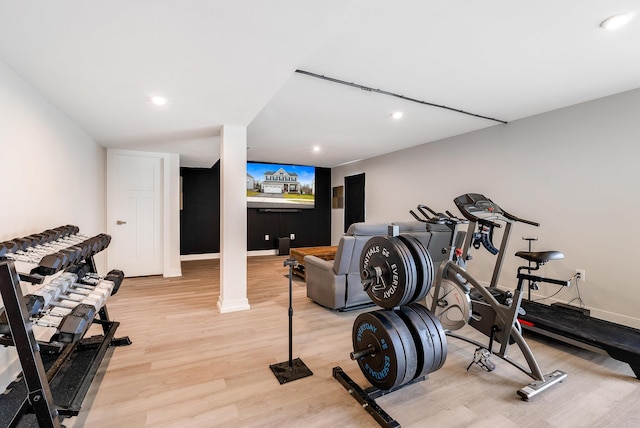 exercise room with light hardwood / wood-style flooring