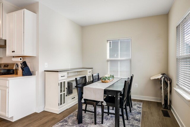 dining room with plenty of natural light and dark hardwood / wood-style floors