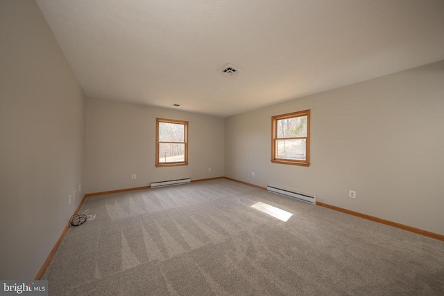 empty room featuring baseboards, baseboard heating, visible vents, and light colored carpet