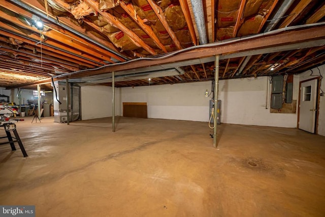 unfinished basement featuring heating unit and electric water heater