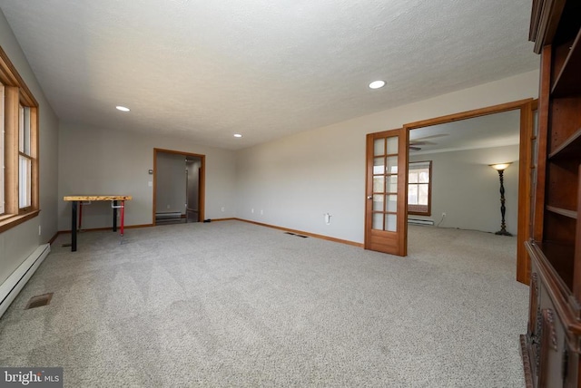 spare room with a textured ceiling, french doors, carpet, and recessed lighting