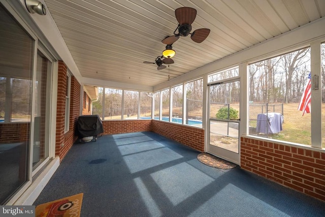 unfurnished sunroom featuring ceiling fan