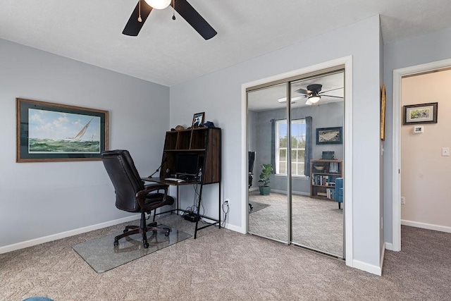 carpeted office with baseboards and a ceiling fan