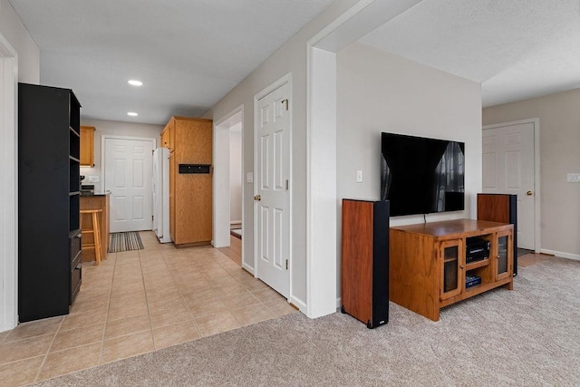 interior space with baseboards, light colored carpet, recessed lighting, and light tile patterned floors