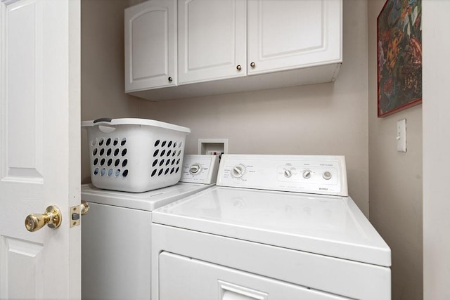 laundry room with washing machine and clothes dryer and cabinet space