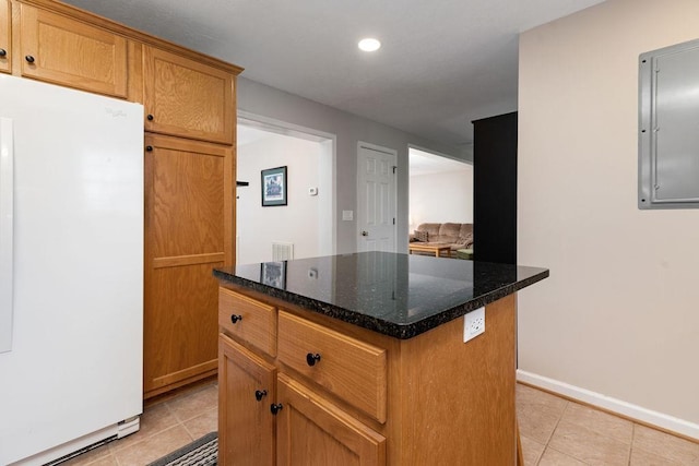 kitchen featuring a center island, light tile patterned flooring, electric panel, freestanding refrigerator, and recessed lighting