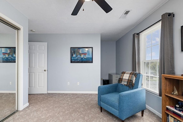 living area with a ceiling fan, carpet floors, and a healthy amount of sunlight