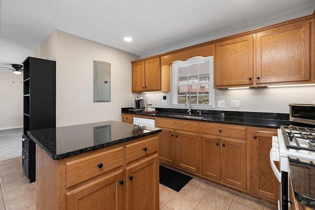 kitchen with white gas stove, a ceiling fan, a sink, light tile patterned flooring, and electric panel