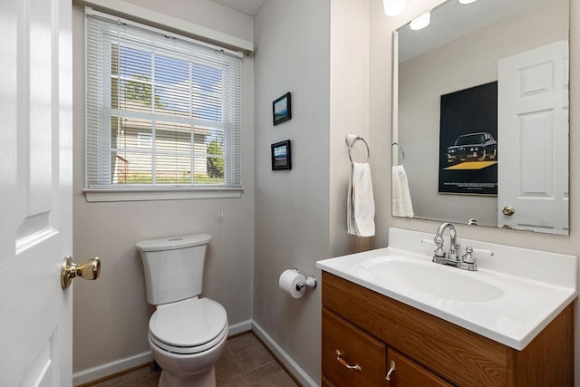 bathroom with baseboards, toilet, vanity, and tile patterned floors