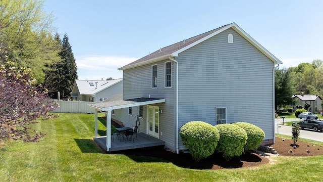 back of house featuring fence, a lawn, and a wooden deck