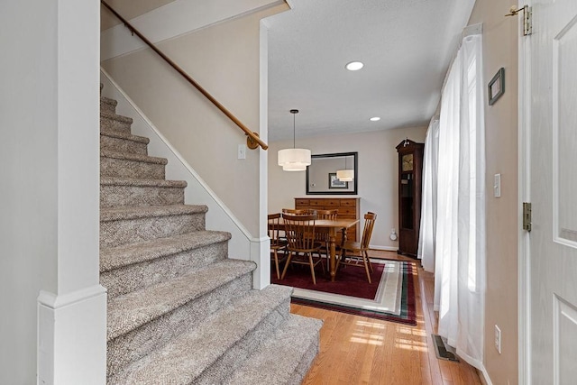 entryway with wood finished floors, stairs, visible vents, and recessed lighting