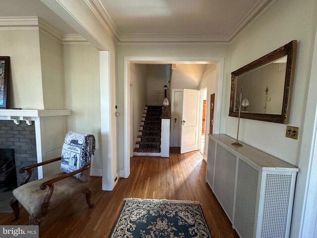 hall with stairs, wood finished floors, baseboards, and ornamental molding