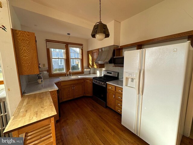 kitchen featuring brown cabinets, a sink, range hood, stainless steel appliances, and light countertops