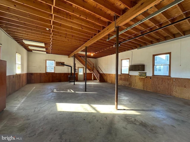 interior space with stairway, wood walls, and wainscoting