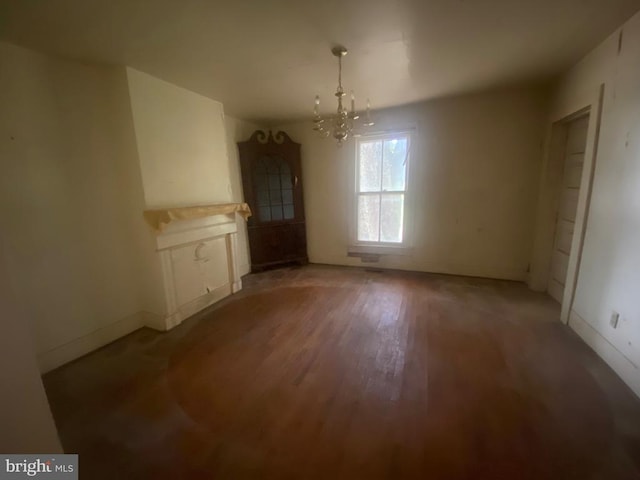 unfurnished dining area featuring an inviting chandelier and hardwood / wood-style flooring