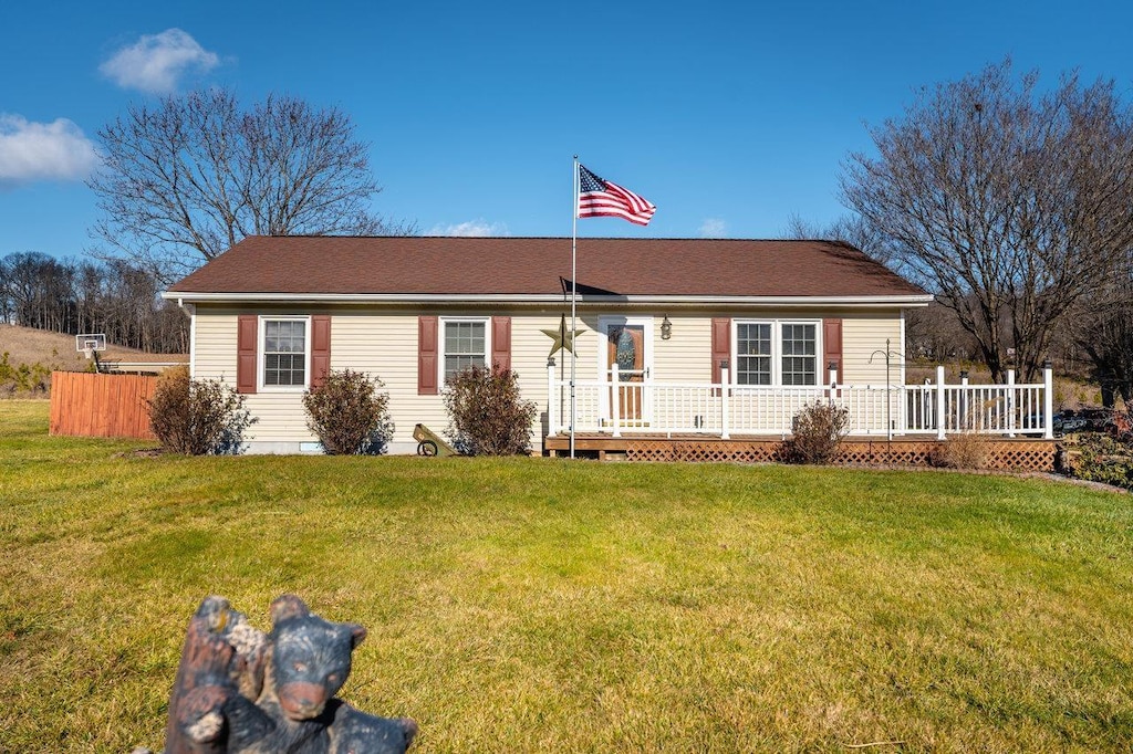 ranch-style house with a wooden deck and a front lawn