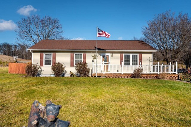 ranch-style house with a wooden deck and a front lawn