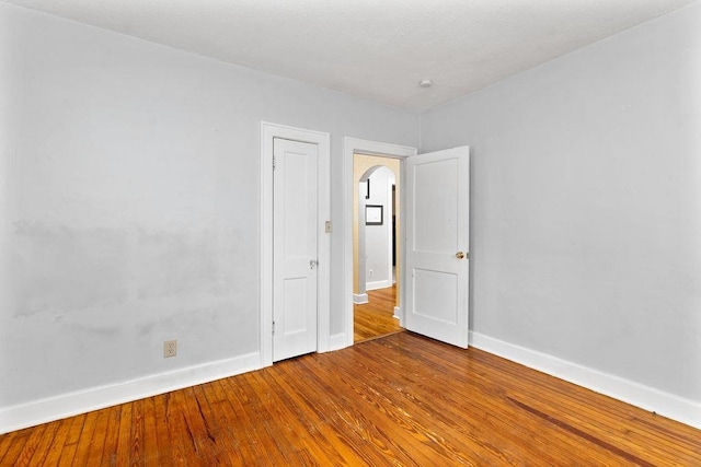 unfurnished room with hardwood / wood-style flooring and baseboards