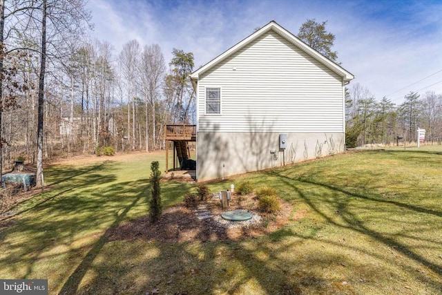 view of side of home featuring a yard and a deck