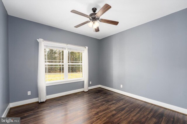 unfurnished room with visible vents, baseboards, a ceiling fan, and dark wood-style flooring