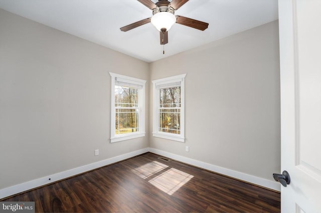 spare room with visible vents, dark wood-type flooring, and baseboards