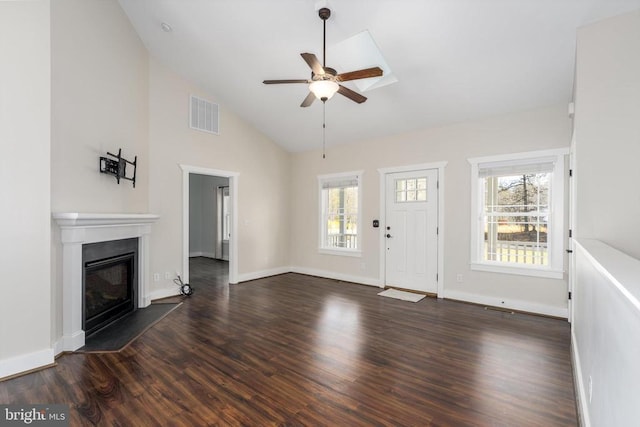 foyer entrance with visible vents, dark wood-type flooring, a ceiling fan, a glass covered fireplace, and baseboards