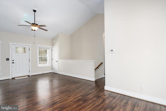 unfurnished living room with baseboards, ceiling fan, dark wood-style flooring, and vaulted ceiling