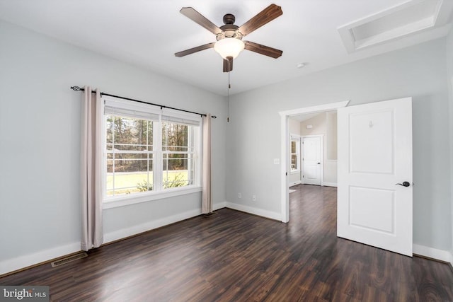 unfurnished room featuring visible vents, dark wood-type flooring, and baseboards