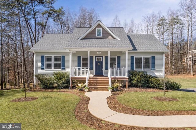 view of front of house featuring covered porch, a front yard, and a shingled roof