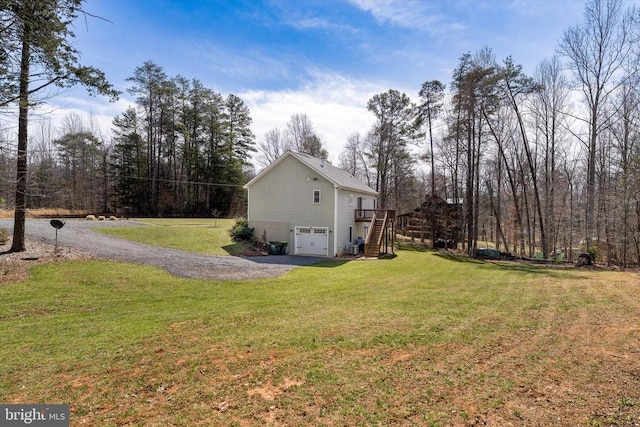 view of home's exterior with a yard, a garage, gravel driveway, and stairs