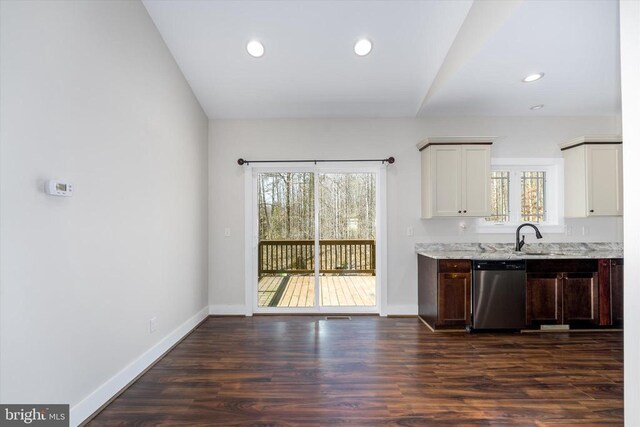 kitchen featuring baseboards, light stone countertops, stainless steel dishwasher, and dark wood-style flooring