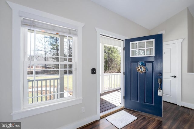 foyer featuring lofted ceiling, dark wood-style floors, and baseboards