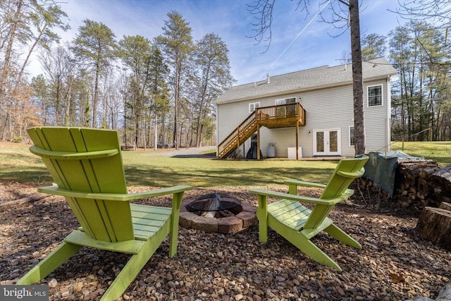 rear view of property featuring a deck, french doors, a yard, a fire pit, and stairs