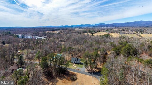 birds eye view of property featuring a forest view and a mountain view