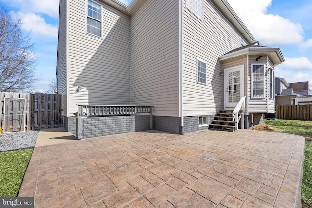 view of side of property featuring entry steps, a patio, and fence