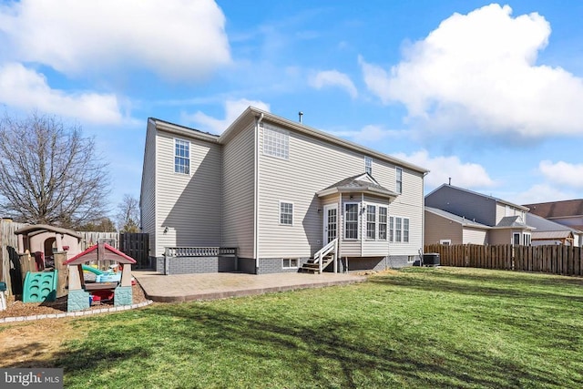 rear view of property with entry steps, a patio, a yard, and a fenced backyard