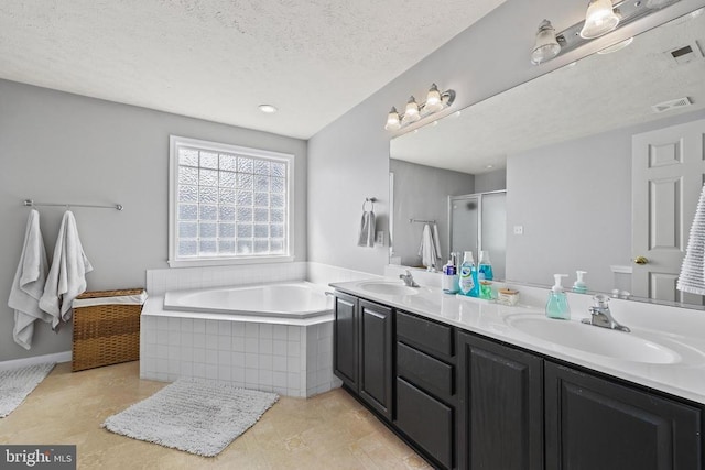 bathroom with a garden tub, double vanity, a sink, and visible vents