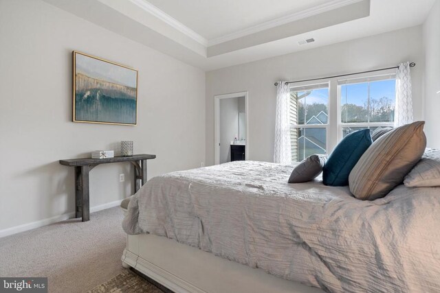 bedroom with a raised ceiling, ornamental molding, and carpet