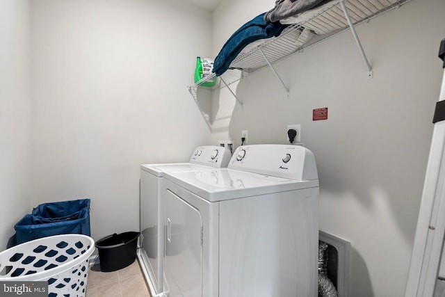 laundry room with light tile patterned floors and washing machine and dryer