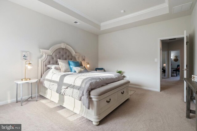 bedroom with ornamental molding, light colored carpet, and a tray ceiling