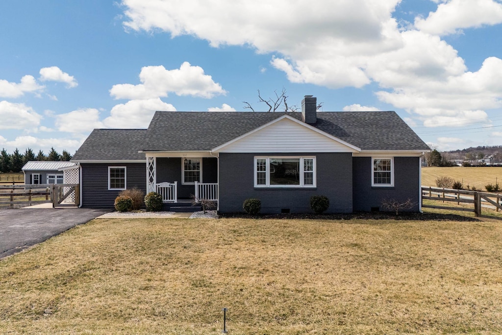 view of front of house with a chimney, crawl space, fence, a front yard, and brick siding