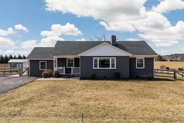 view of front of house with a chimney, crawl space, fence, a front yard, and brick siding