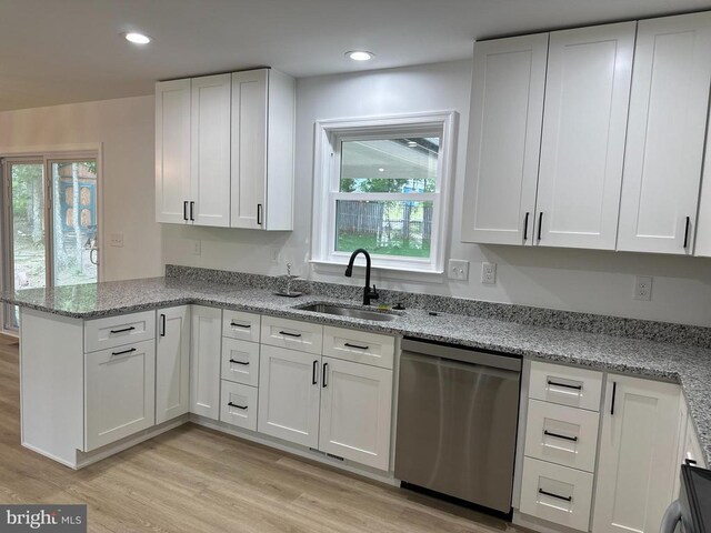 kitchen with white cabinetry, dishwasher, sink, and light stone countertops