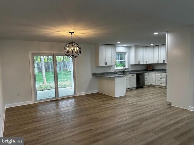 kitchen featuring sink, white cabinetry, decorative light fixtures, black dishwasher, and hardwood / wood-style floors