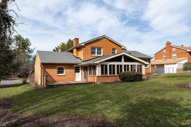 back of house featuring a deck, a lawn, brick siding, and a chimney